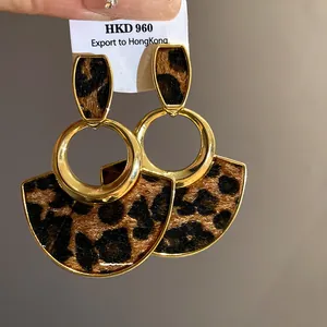 Detailed macro view of leopard print hollow oval earrings with gold-tone finish
