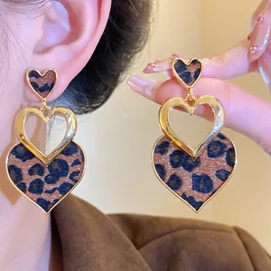 Detail view of stylish heart-shaped leopard print earrings with gold metal frames.