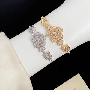 Elegant silver and gold rose flower bracelets with sparkling zircons worn on wrist