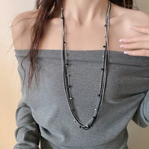 Dettaglio elegante di una collana multistrato con perline di vetro su modella asiatica