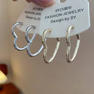 Close-up detail of silver and gold heart-shaped hoop earrings on display cards