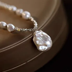 Macro view of a baroque pearl necklace with a large irregular water drop pendant