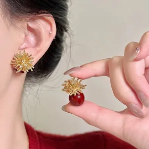 Dettaglio macro di eleganti orecchini a bottone a fuoco d'artificio con perle rosse e strass