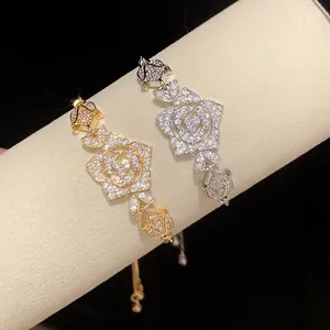Detailed view of elegant gold and silver floral bracelets with shimmering zircon stones