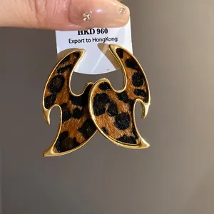 Close-up of the leopard print texture and gold plating on flame-shaped earrings