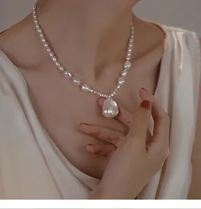 Close-up detail of a French Baroque irregular teardrop pearl necklace on a model's neck