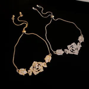Detailed view of elegant gold and silver bracelets featuring zircon-encrusted flower pendants