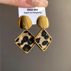 Close-up view of elegant leopard print square earrings with gold-plated metal studs