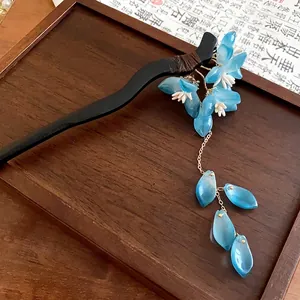 Elegant New Chinese style hair stick with blue flowers and tassels on a wooden tray.
