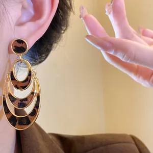 Close-up of stylish leopard print hollow oval earrings showing detailed texture and wear
