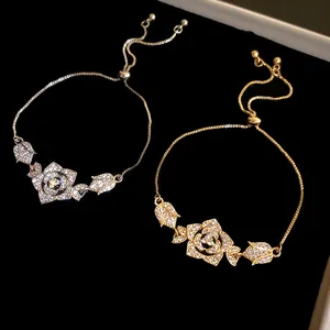 Close-up of elegant gold and silver bracelets with sparkling zircon rose charms