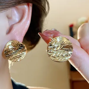 18k gold plated circular stud earrings with a textured pleated design shown worn on ear