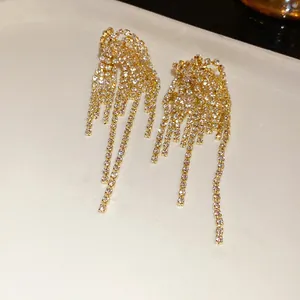 Primo piano di eleganti orecchini in argento dorato con nappe a cascata in strass