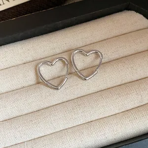 Close-up of minimalist silver heart-shaped hoop earrings in a jewelry box
