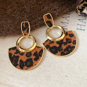 Detailed macro shot of vintage leopard print earrings with gold metal accents.