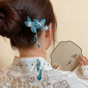 Elegant blue flower hair pin with long tassels shown worn on a model's bun in Chinese style