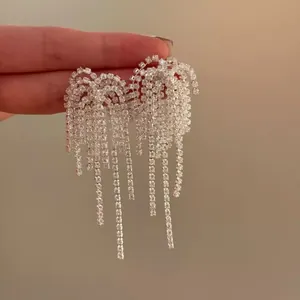 Vista macro di orecchini con nappe in argento scintillante e dettagli in strass