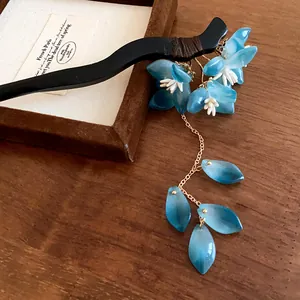Close-up of elegant blue flower hair stick with dangling tassel for traditional styling