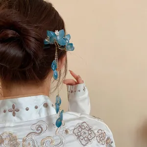 Detail view of a blue flower tassel hairpin styled in an elegant hair bun for women