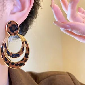 Close-up view of stylish leopard print hollow oval earrings showing furry texture