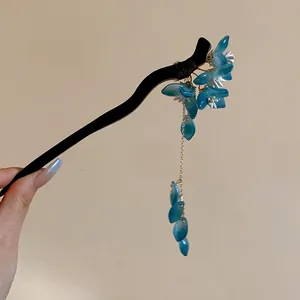 Close-up of an elegant Chinese style hair stick featuring blue flowers and delicate tassels