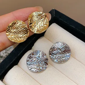 Close-up of 18k gold plated round stud earrings with wrinkled texture design