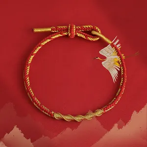 Nahaufnahme eines handgefertigten rot-goldenen geflochtenen Armbands mit Schlangentextur