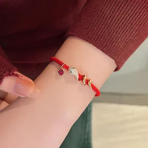 Elegantes vergoldetes Schlangenkopf-Armband aus roter Schnur mit glitzernden Zirkon-Anhängern