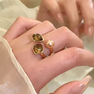 Detaillierte Makroaufnahme eines vergoldeten offenen Rings mit Perle und Kristallen