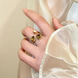 Elegante Nahaufnahme eines vergoldeten offenen Rings mit bernsteinfarbenen Kristallen