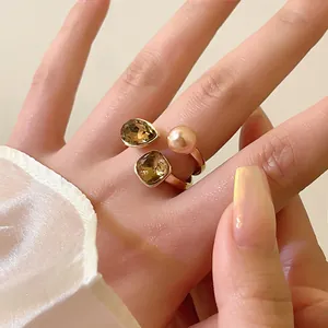 Detailansicht eines vergoldeten Retro-Rings mit Perlen und bernsteinfarbenen Kristallen