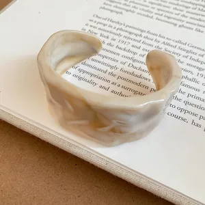 Primo piano dettagliato di un bracciale rigido vintage in acrilico beige marmorizzato