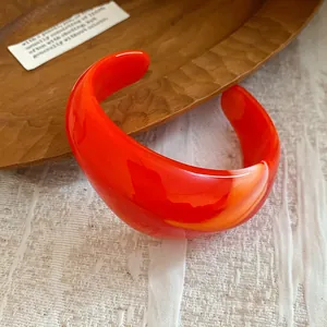 Bracciale rigido in resina marmorizzata arancione vibrante con stile dopamina unico