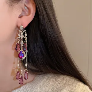 Dettaglio di orecchini vintage a nappa in cristallo viola indossati da una modella