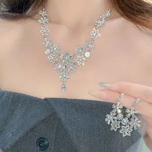 Detailed view of vintage silver flower necklace and earring set with sparkling rhinestones
