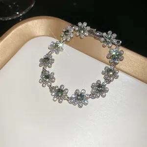 Detail of flower-shaped silver bracelet with green stones and sparkling crystals