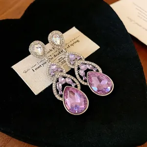 Elegant purple teardrop dangle earrings with sparkling rhinestones for a luxury look.