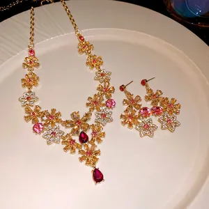 Detailed view of vintage gold necklace and earring set with pink rhinestone flowers.