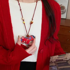 Detail view of a handcrafted red horse embroidery pendant necklace with wooden beads.