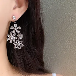 Close-up of elegant vintage floral drop earrings featuring shimmering crystals on model
