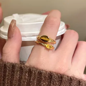 Close-up detail of vintage 18k gold plated open ring with tiger eye and zircon