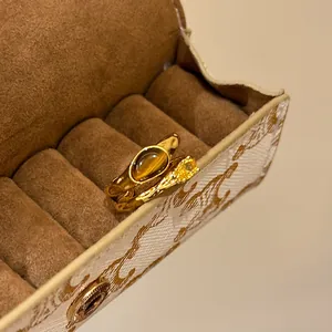 Close-up of vintage 18k gold plated rings with tiger's eye and yellow zircon gemstone