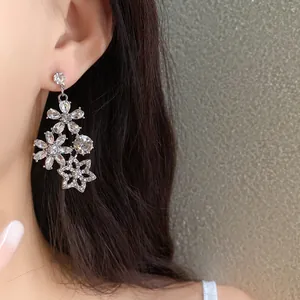Detailed view of vintage floral drop earrings with rhinestones on an Asian model.