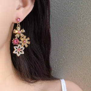Detailed close-up of vintage vintage-style floral drop earrings with pink rhinestones on model
