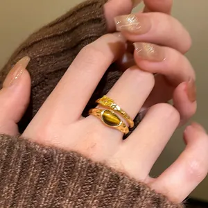 Detail of retro 18k gold plated rings featuring tiger eye stone and yellow zircon