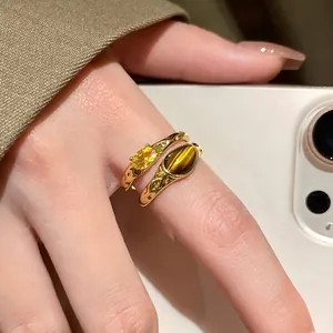 Macro view of 18k gold plated open ring featuring tiger-eye stone and yellow zircon
