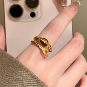Macro view of 18k gold plated open ring featuring tiger eye stone and yellow zircon