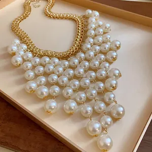 Detailed close-up of a vintage gold chain necklace with layered pearl fringe tassels