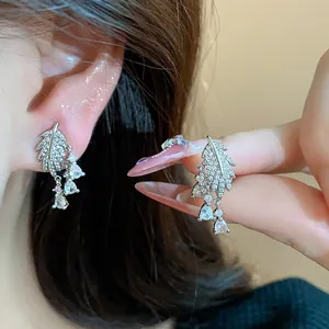 Dettaglio di orecchini a foglia placcati in oro 18k con zirconi brillanti