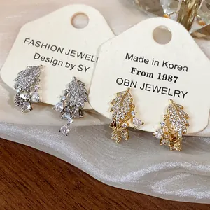 Vista dettagliata dei clip per orecchie a foglia placcati oro 18k con zirconi scintillanti